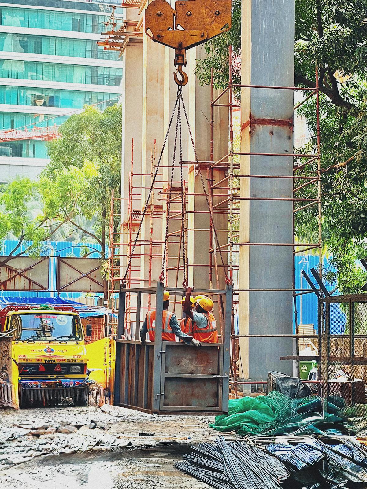 Construction workers operating a crane at an active construction site